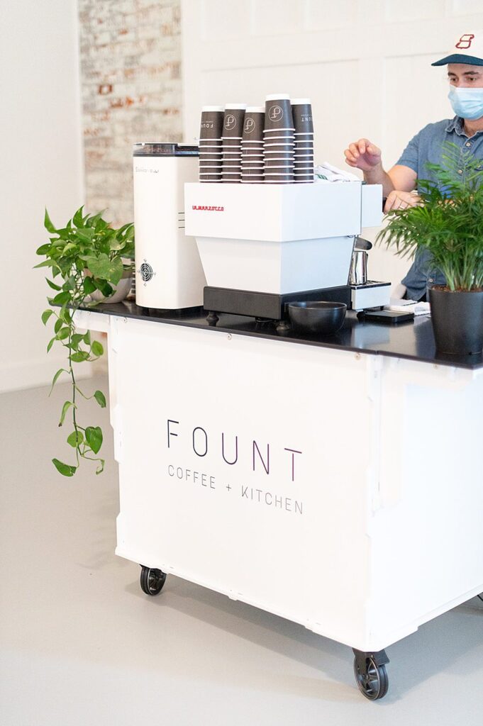 White coffee cart that says Fount Coffee + Kitchen at an event at The Graham Mill in NC.