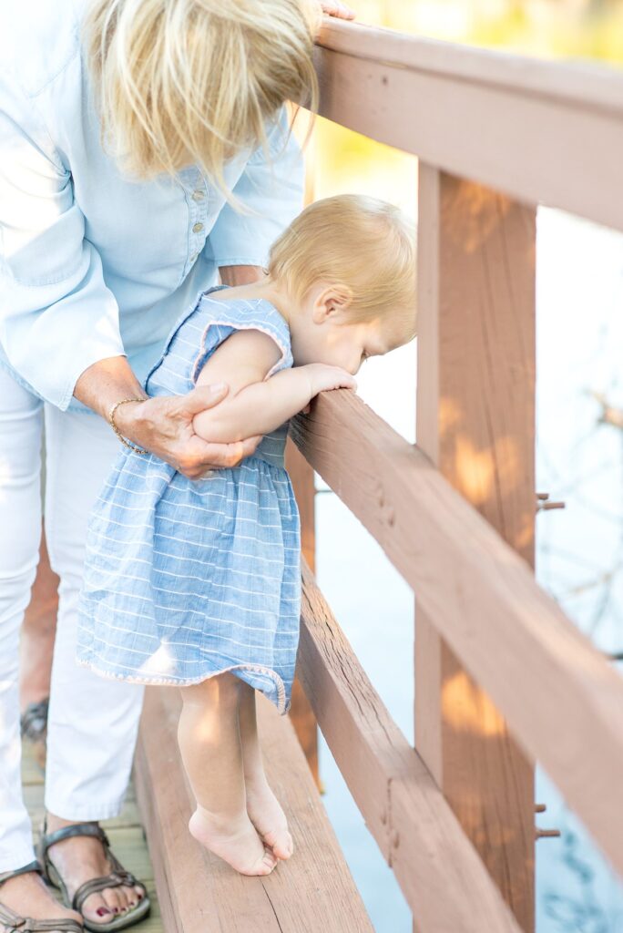 Child looking over a railing to the water. Family photos by Mikkel Paige Photography on Marco Island.