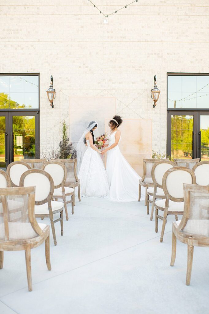 Two brides at an outdoor ceremony at The Maxwell, a modern wedding venue.