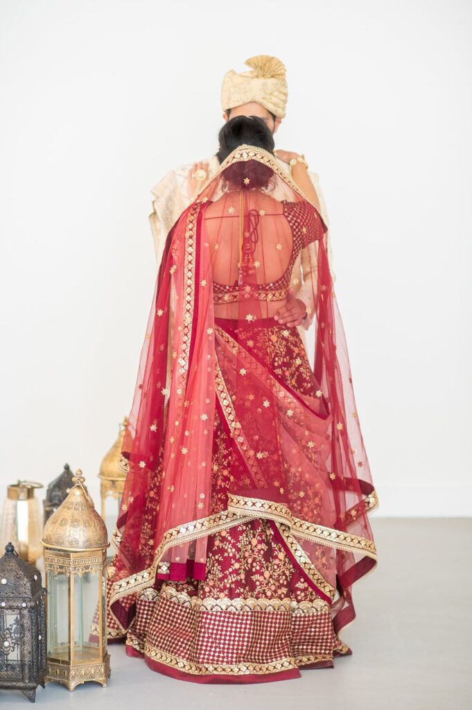 Back of an Indian bride dressed in a red sari and veil.