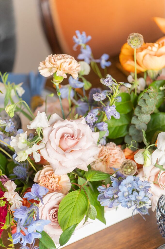 Flowers as the centerpiece at a colorful Indian wedding in NC in orange, blue, pink and green.