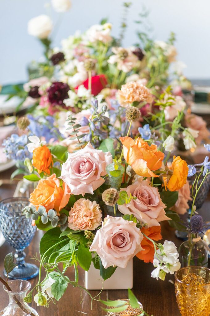 Flowers as the centerpiece at a colorful Indian wedding in NC in orange, blue, pink and green.
