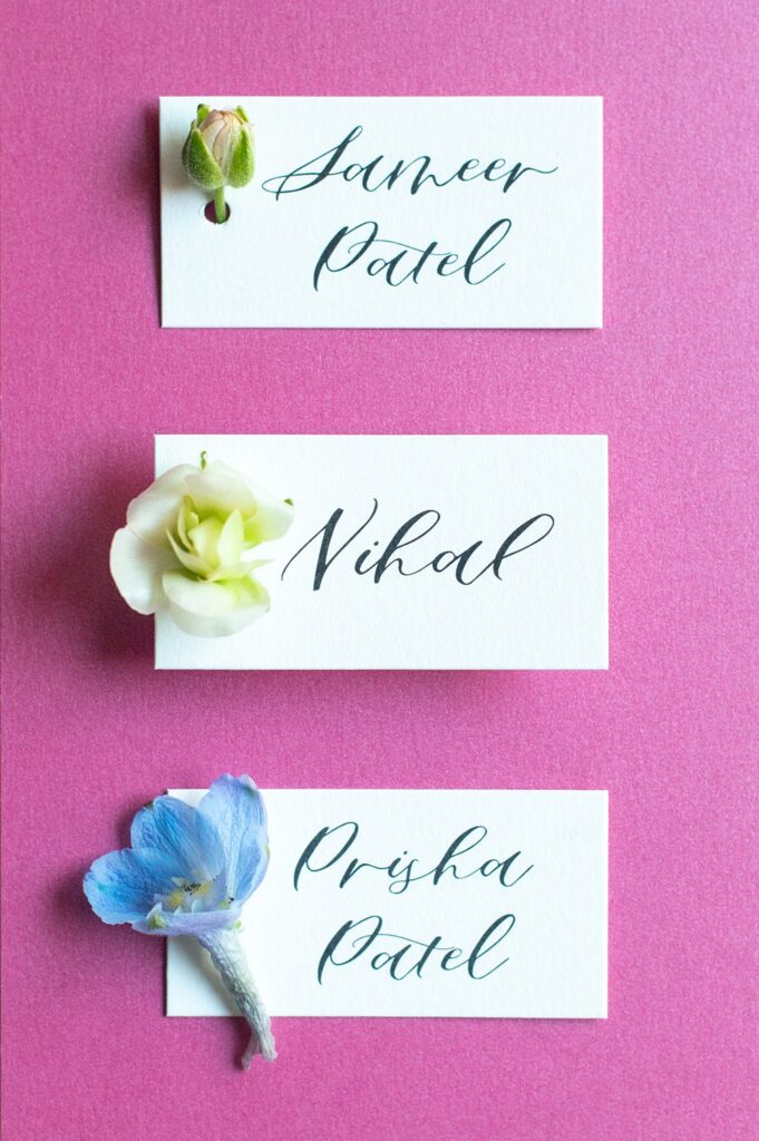 Black calligraphy on white place cards for a colorful Indian wedding in North Carolina.