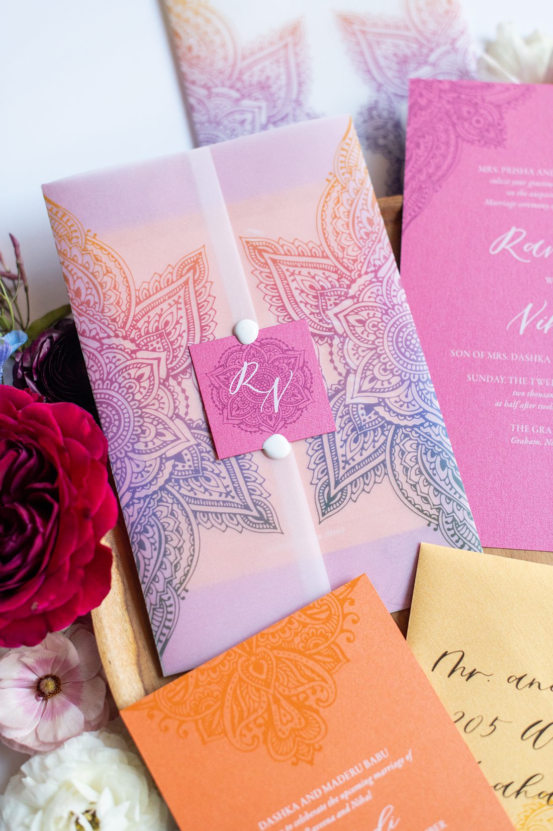 Colorful Indian wedding invitation with the Sangeet, Mehndi, Baraat and wedding events included by Coqui Paperie. Flat lay pictures by Mikkel Paige Photography.