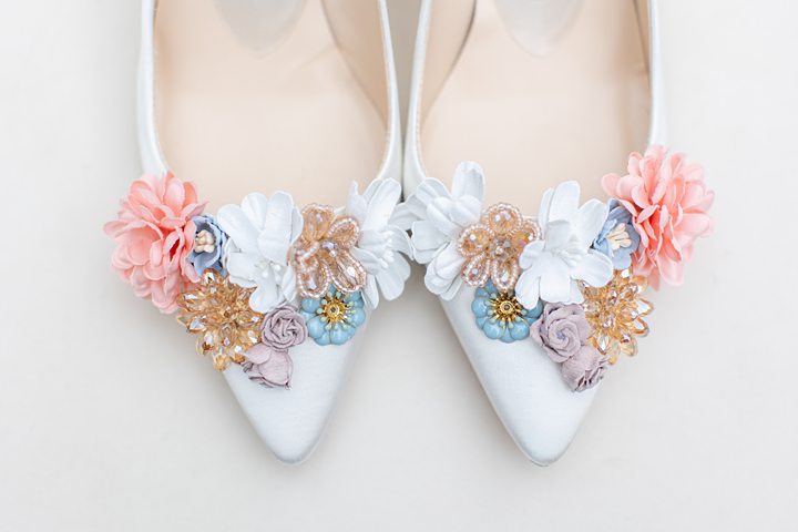 Shoes with white, taupe, blue and peach flowers.