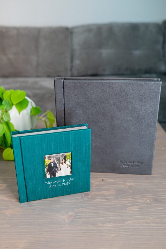 Green silk parent wedding album next to a larger grey leather couple's album by Mikkel Paige Photography.