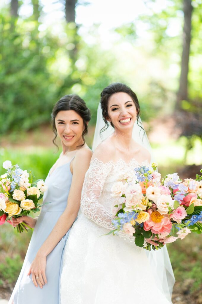 Bride with her bridesmaid in blue, with colorful flowers at The Umstead
