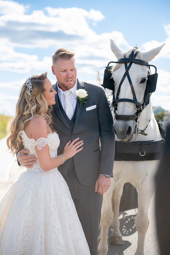 Bride and groom with a horse drawn carriage at their NJ wedding. Image by Mikkel Paige Photography.