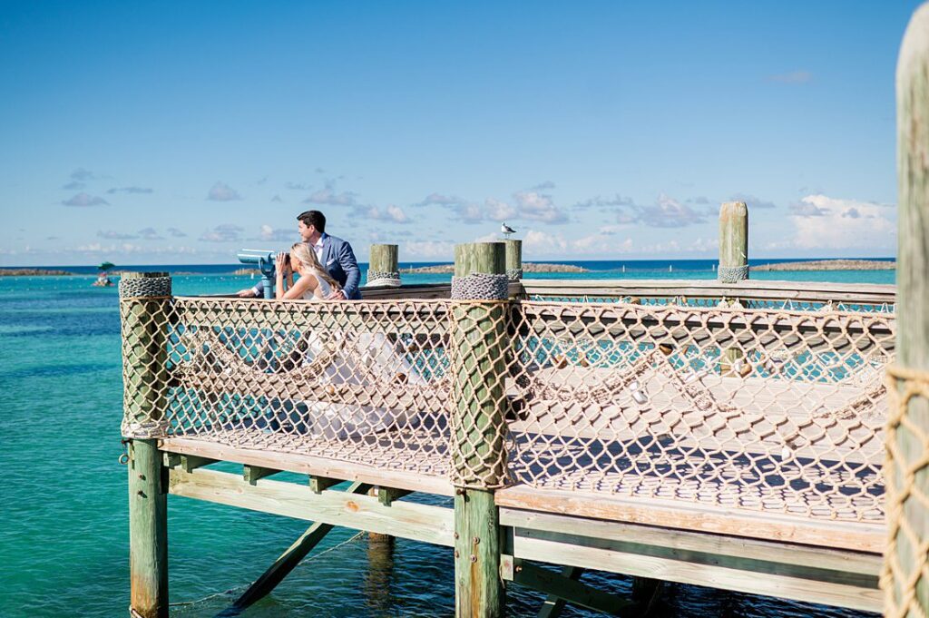 Bride and groom looking out to the turquoise water on Castaway Cay for wedding photos. Pictures by Mikkel Paige Photography.