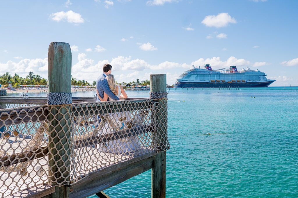 Bride and groom looking out to the turquoise water on Castaway Cay for wedding photos. Pictures by Mikkel Paige Photography.