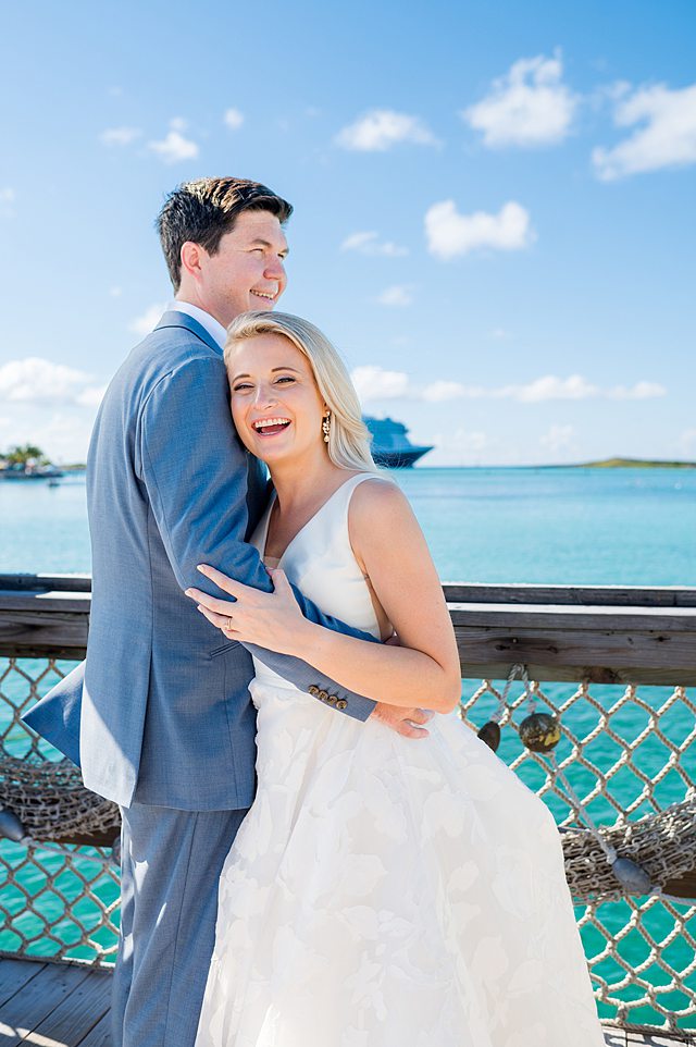 Bride and groom near the turquoise water on Castaway Cay for wedding photos. Pictures by Mikkel Paige Photography.