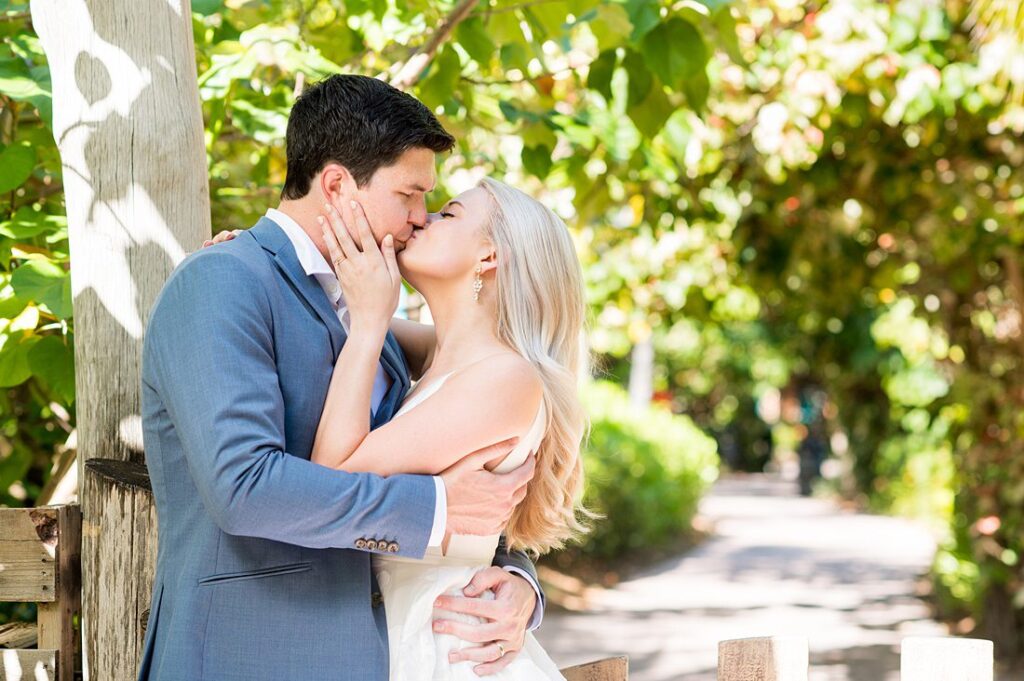 Bride and groom with lush tropical foliage behind them for Castaway Cay wedding photos. Pictures by Mikkel Paige Photography.