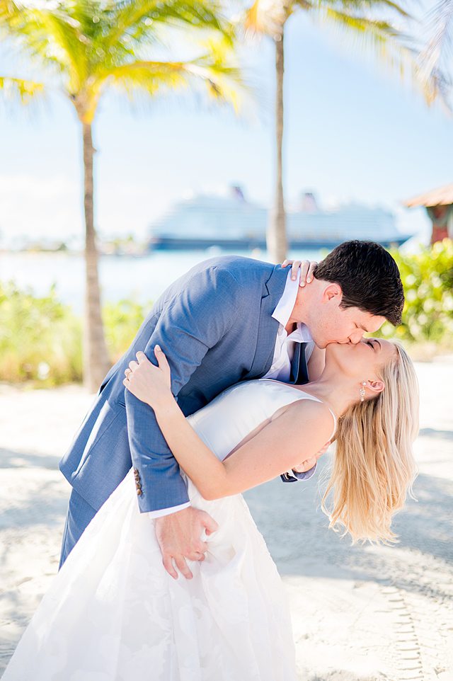 Bride and groom kissing and doing a dip on Castaway Cay for wedding photos by Mikkel Paige Photography.
