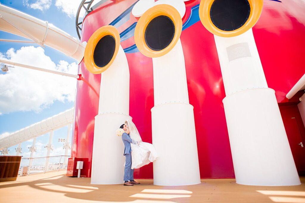 Disney Wish wedding photos by Mikkel Paige Photography of the bride and groom by the red and yellow Mickey stack.