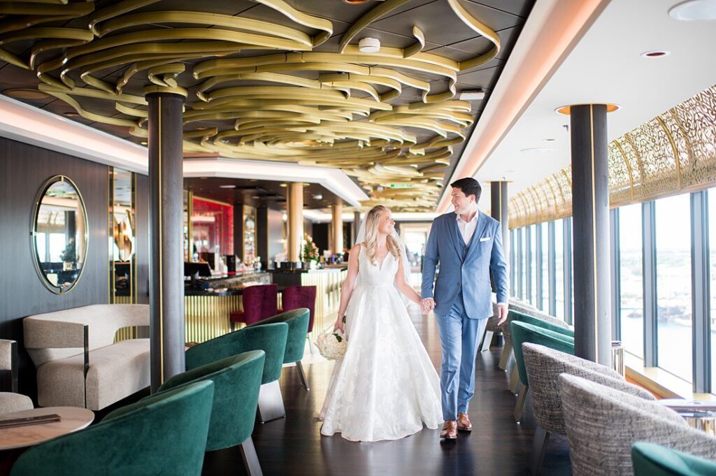 Couple walking in The Rose bar on Disney Wish in their Disney Cruise Line wedding photos by Mikkel Paige Photography.