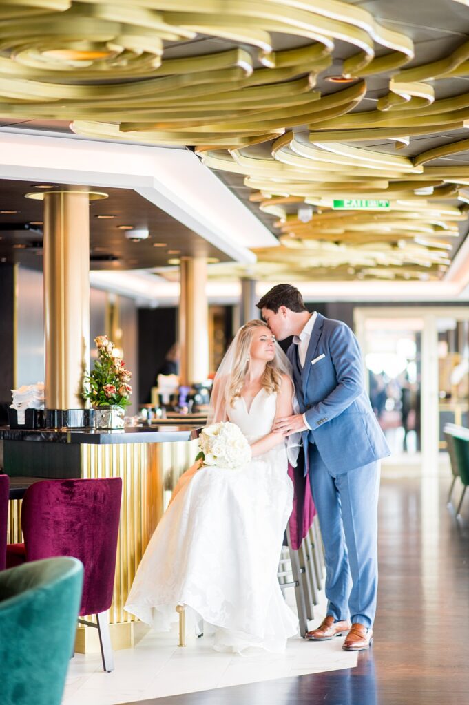 Groom kissing the bride in The Rose bar on Disney Wish in their Disney Cruise Line wedding photos by Mikkel Paige Photography.