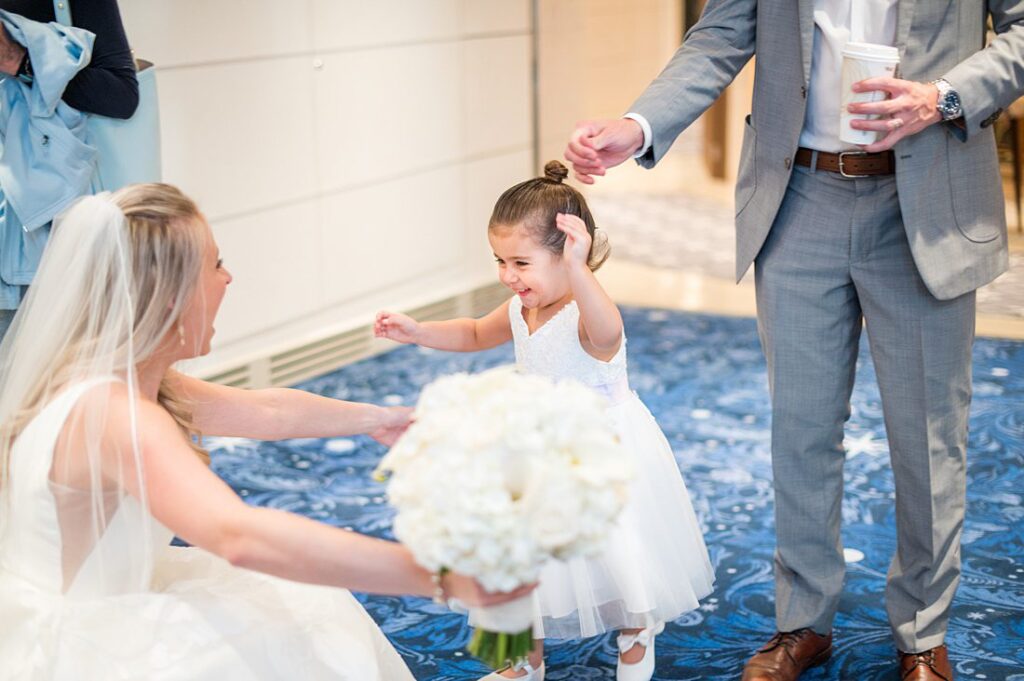 Flower girl running toward the bride on Disney Wish on the bride's wedding day on Disney Cruise Line. Photos by Mikkel Paige Photography.