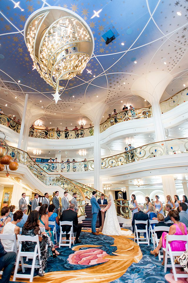 Indoor wedding ceremony in the grand hall on Disney Wish. Photos by Mikkel Paige Photography.