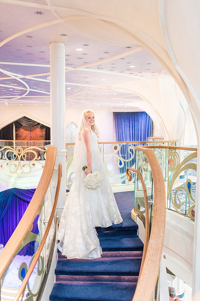 Disney Wish wedding photos by Mikkel Paige Photography of the bride on the grand hall stairs.