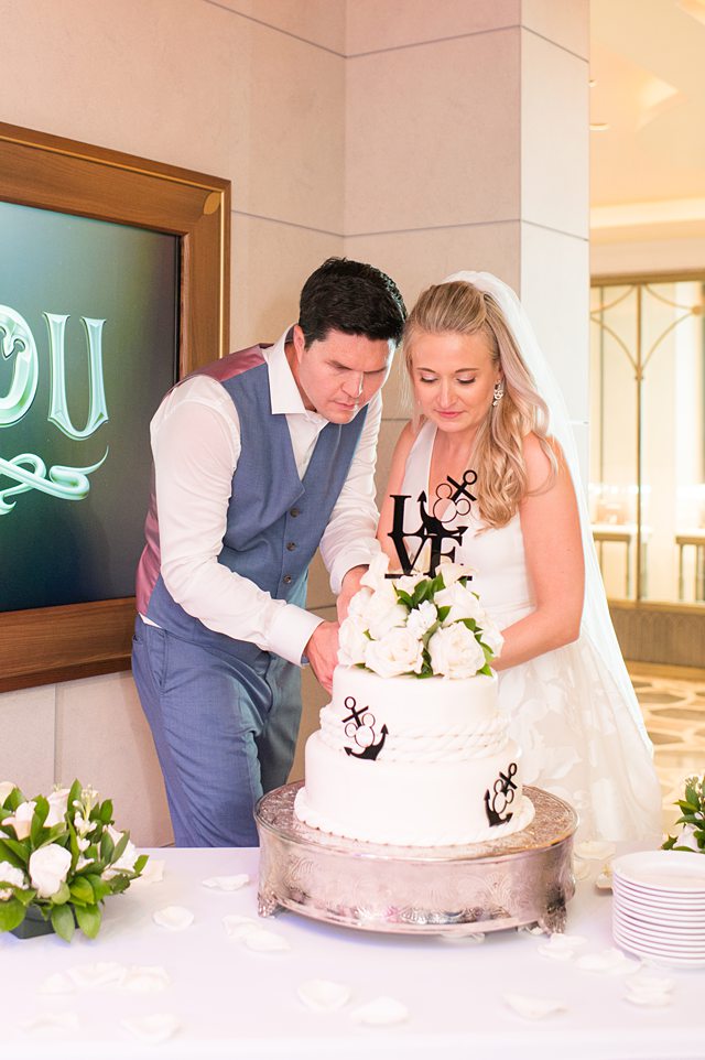 Bride and groom cutting their Disney Cruise Line wedding cake for a Disney Wish wedding with photos by Mikkel Paige Photography.