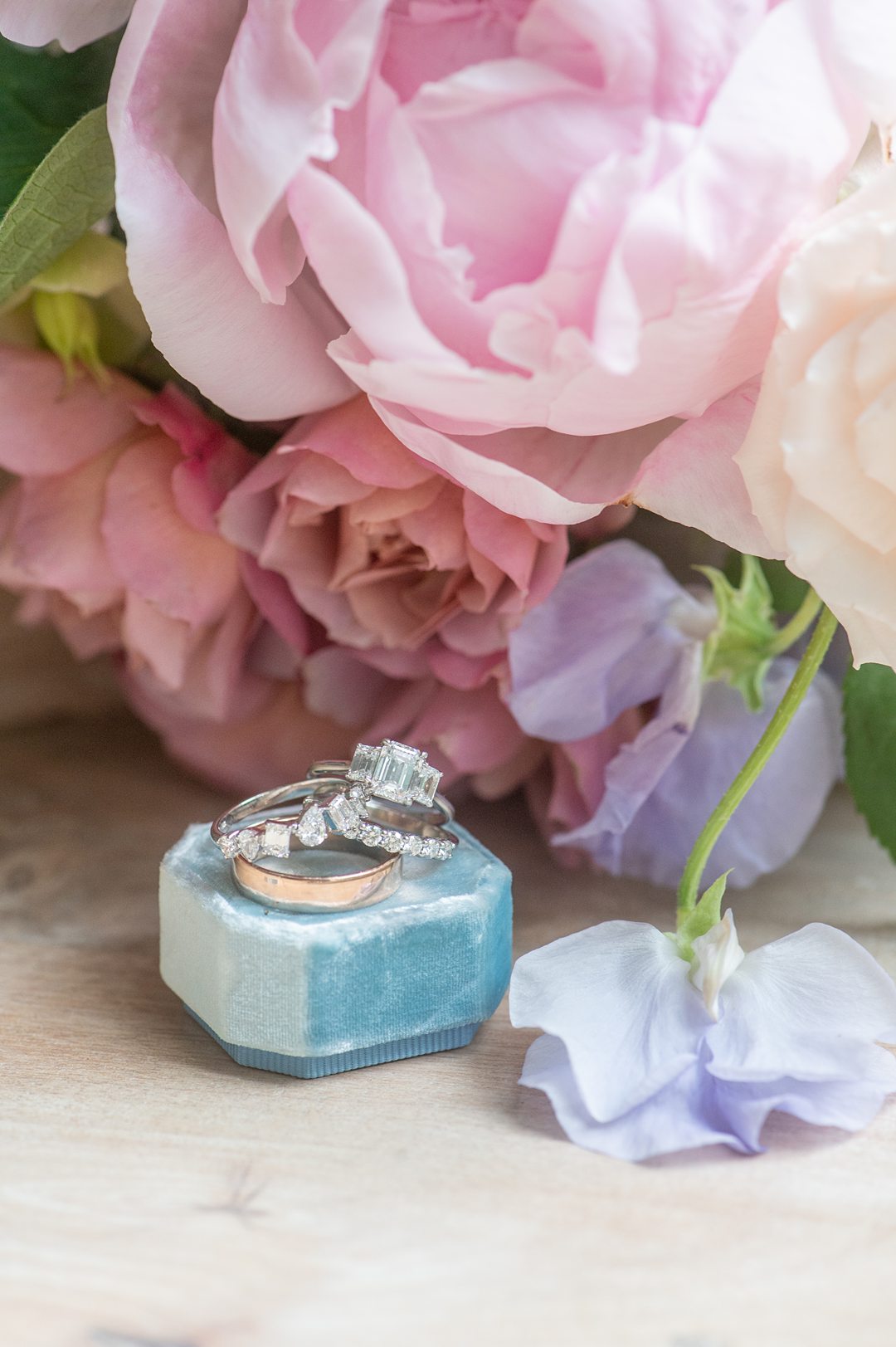 Ring photos of white gold and emerald cut stones on a light blue velvet ring box at Carolina Grove in NC by Mikkel Paige Photography.