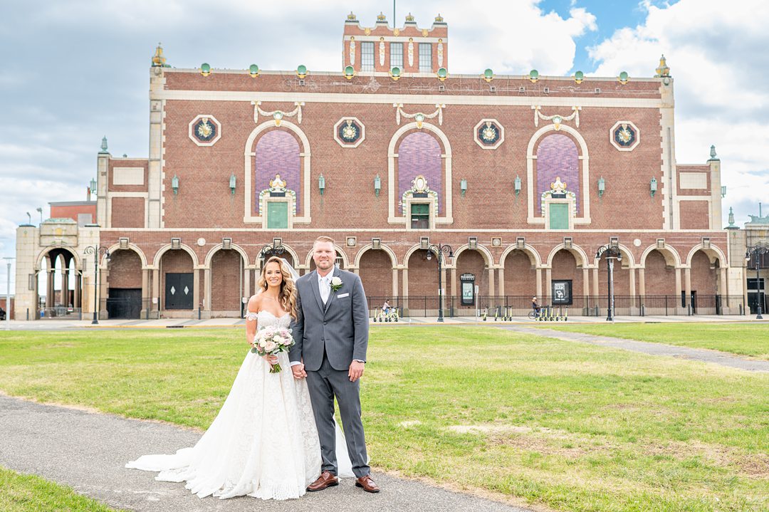 Bride and groom in front of Asbury Park convention center, NJ on their wedding day. Photos by Mikkel Paige Photography.