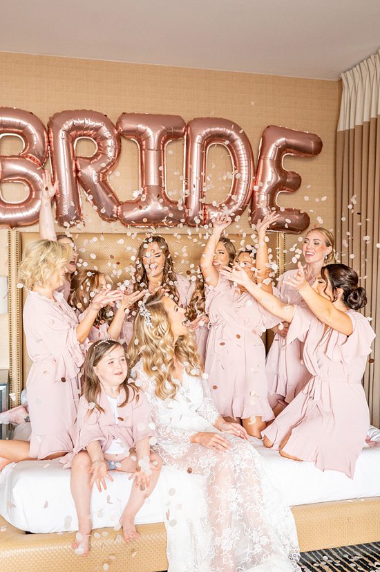 Bride and her bridesmaids with confetti at Asbury Park, NJ for a wedding starting at the Berkley Hotel. Photos by Mikkel Paige Photography.