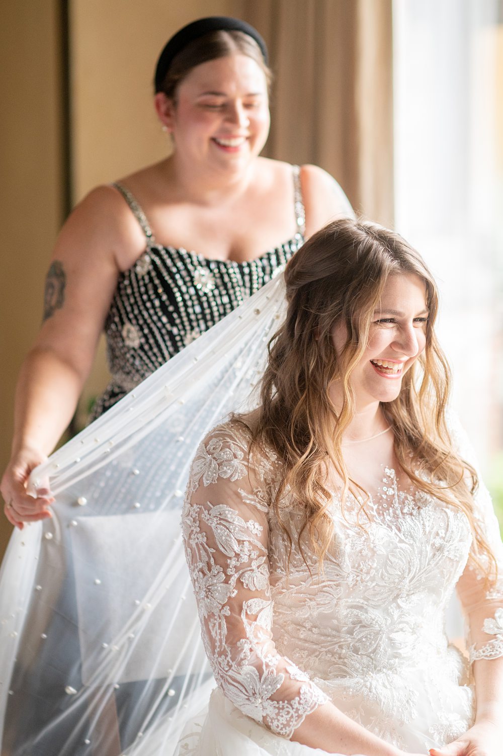 A bride and her best friend putting on her veil at a Blue Hill Stone Barns wedding