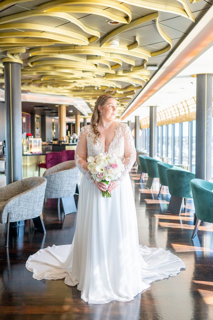 Bride looking out the window of The Rose bar during her Disney Wish wedding on a cruise ship.