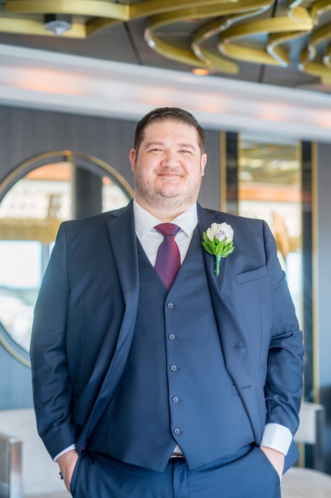 Groom in a navy double-breasted suit at The Rose on Disney Wish for his wedding day.