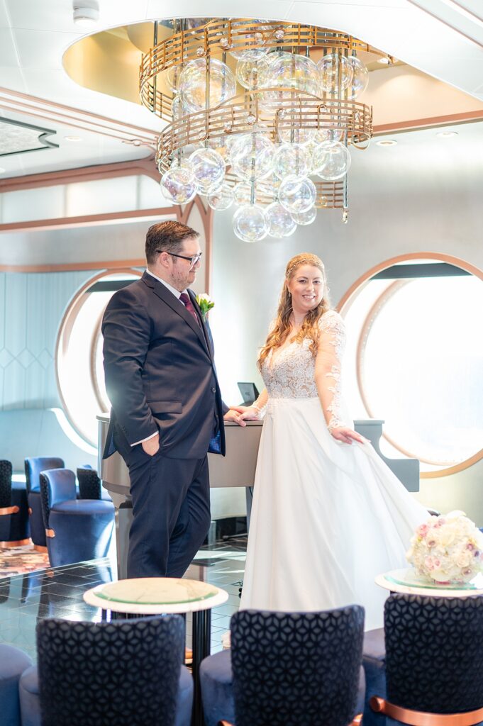 Bride and groom by the grand piano in Nightingale's on Disney Wish during their wedding day.