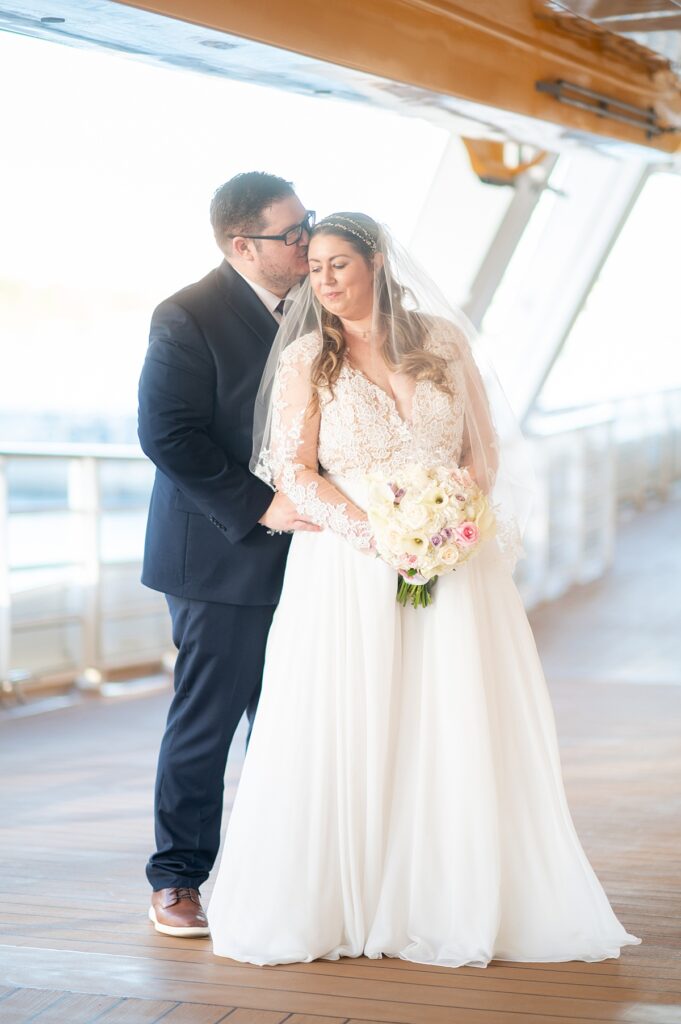 Bride and groom on an exterior deck of Disney Wish during their wedding day in the Caribbean.