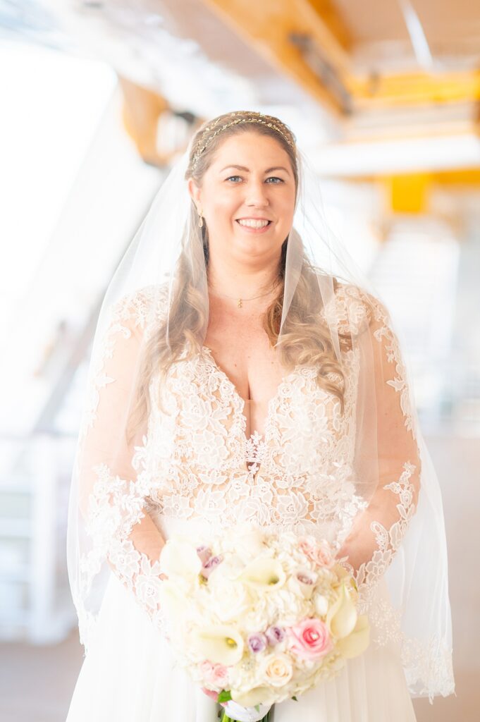 Bride in her veil on an exterior deck of Disney Wish during their wedding day in the Caribbean.