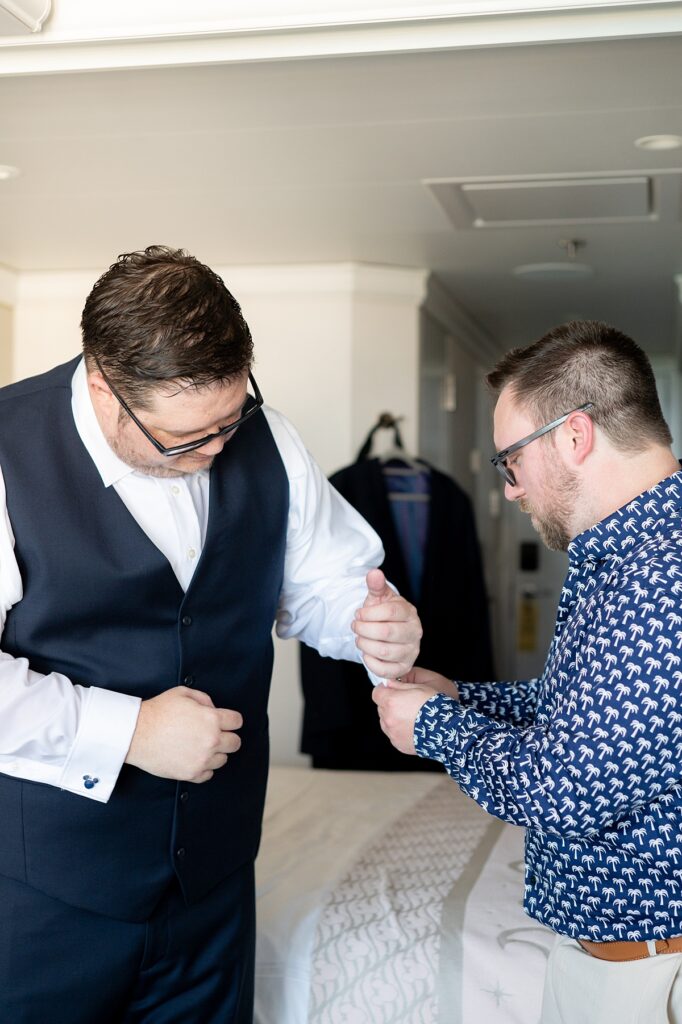 Groom getting ready for his Disney Cruise Line wedding at the Bayou, with his best man helping put his cufflinks on.