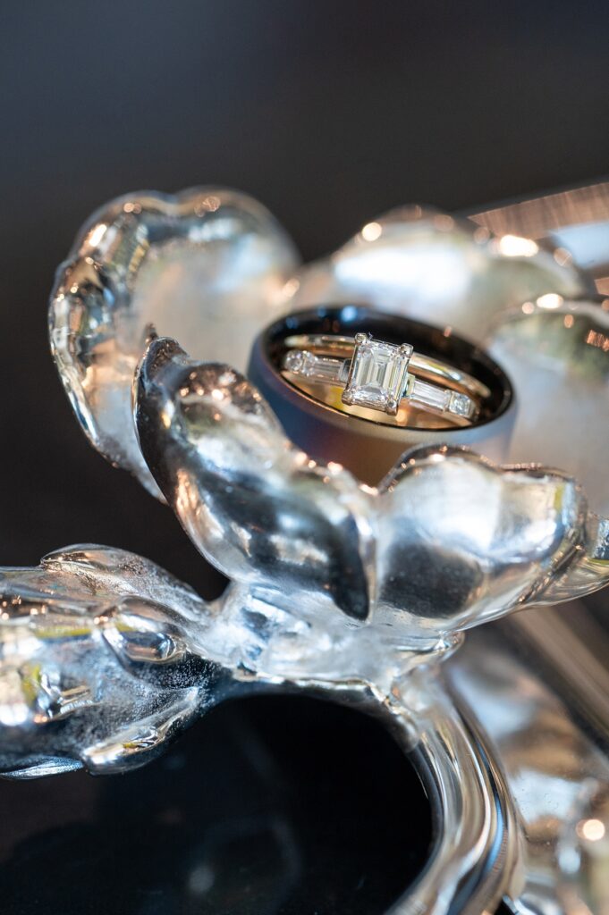 Engagement ring and wedding bands on a silver flower for a Disney Wish cruise wedding in The Bayou.