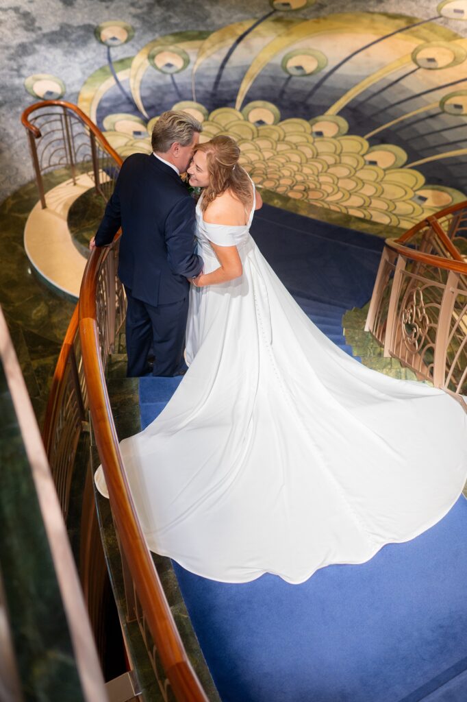 Bride and groom on the grand staircase of Disney Fantasy cruise ship.