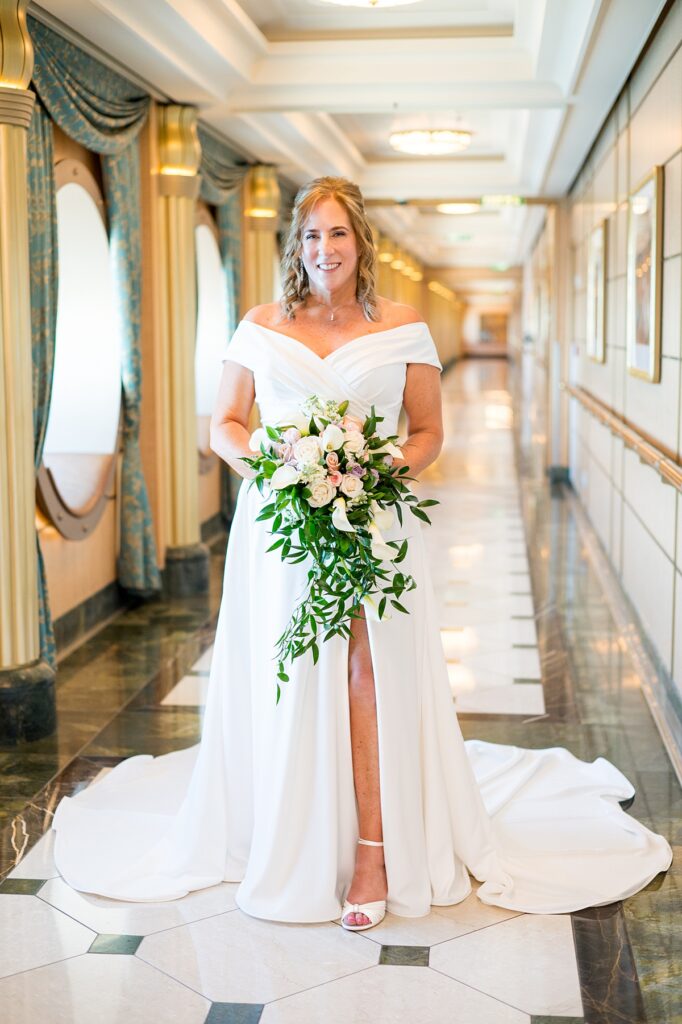 Bride with a cascading bouquet and off the shoulder wedding gown from a Disney Fantasy cruise line wedding.