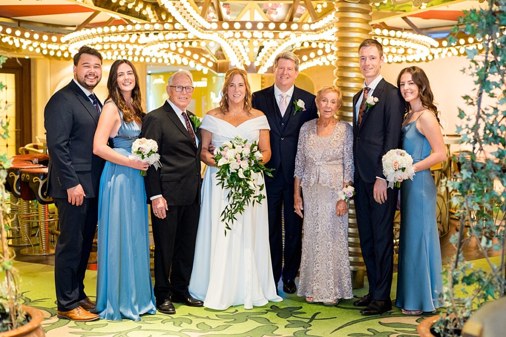 Family with three generations posing for a photo at La Piazza on Disney Fantasy for a cruise wedding.