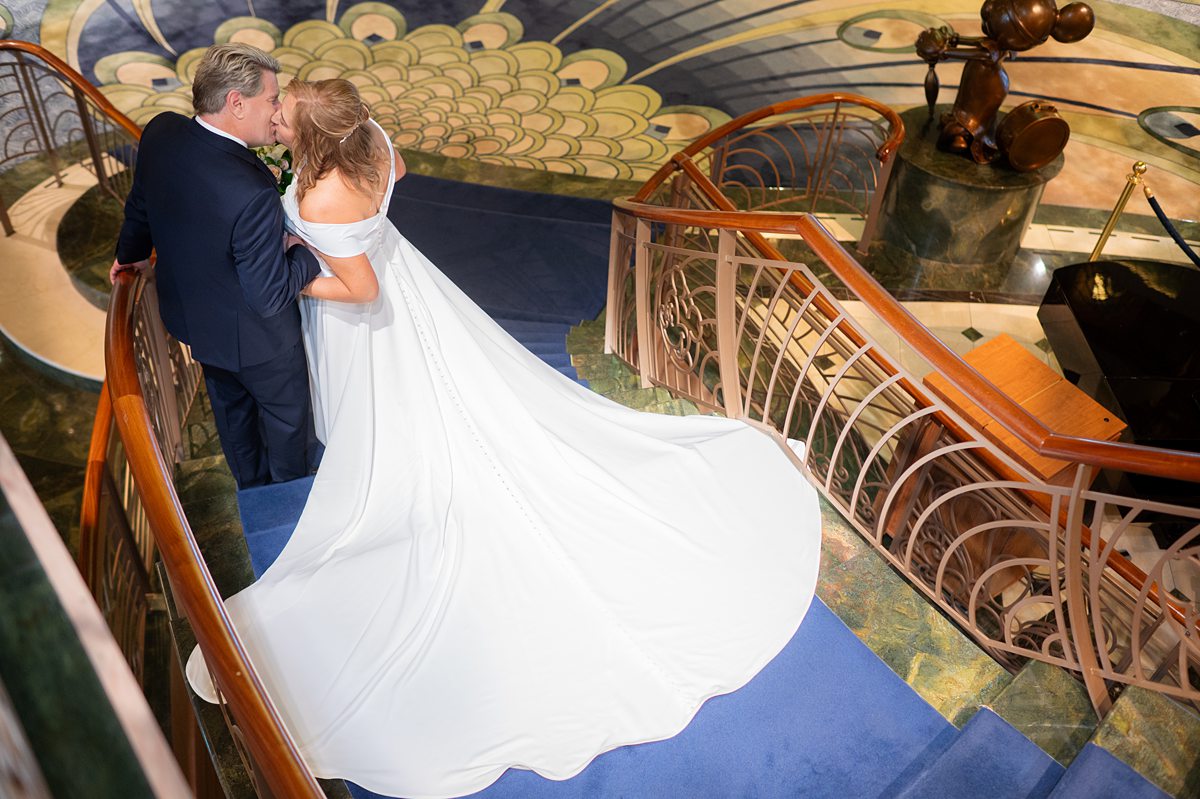 Disney Fantasy wedding with a bride and groom on the staircase on the cruise line.