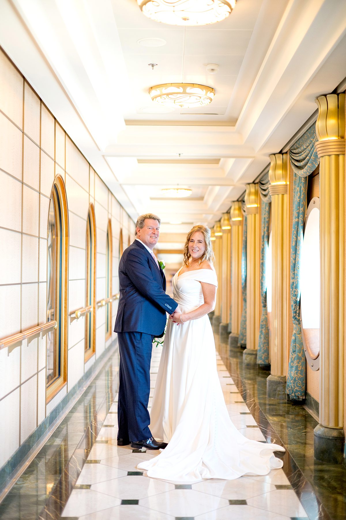 Disney Fantasy wedding with a bride and groom walking in a hallway with curtains and gold columns.