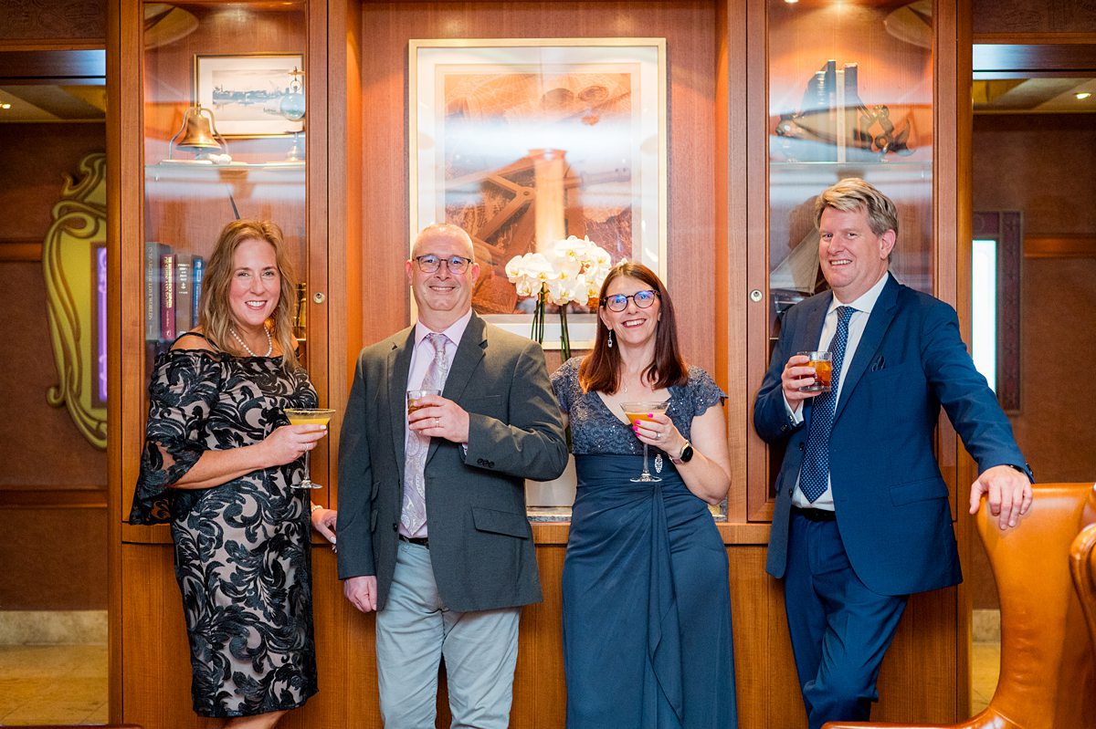 Two couples in formal attire holding cocktails at Meridian bar on Disney Fantasy.